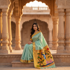 Woman in a traditional saree sitting in an architectural setting