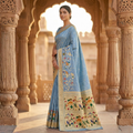 Woman in a traditional saree standing in an architectural setting