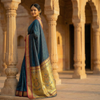 Woman in a traditional saree standing in an architectural setting