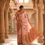 Woman in a traditional saree standing in an architectural setting with floral decorations.