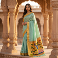 Woman in a traditional saree standing in an architectural setting