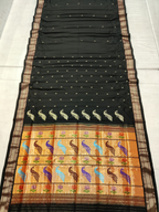 Black saree with colorful peacock and floral patterns on a white background