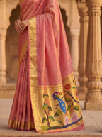 Pink saree with a colorful design draped over a traditional architectural background